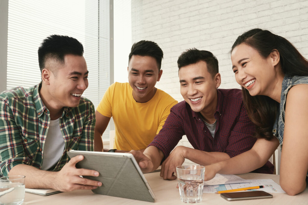 a group of people happily looking at a tablet