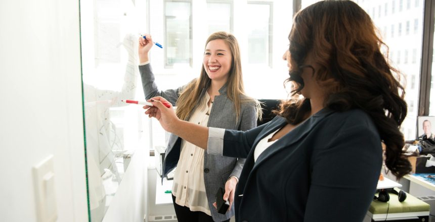 Two female co-workers discussing about a project