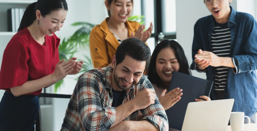 A group of colleagues smiling and happily enjoying the remote team meeting